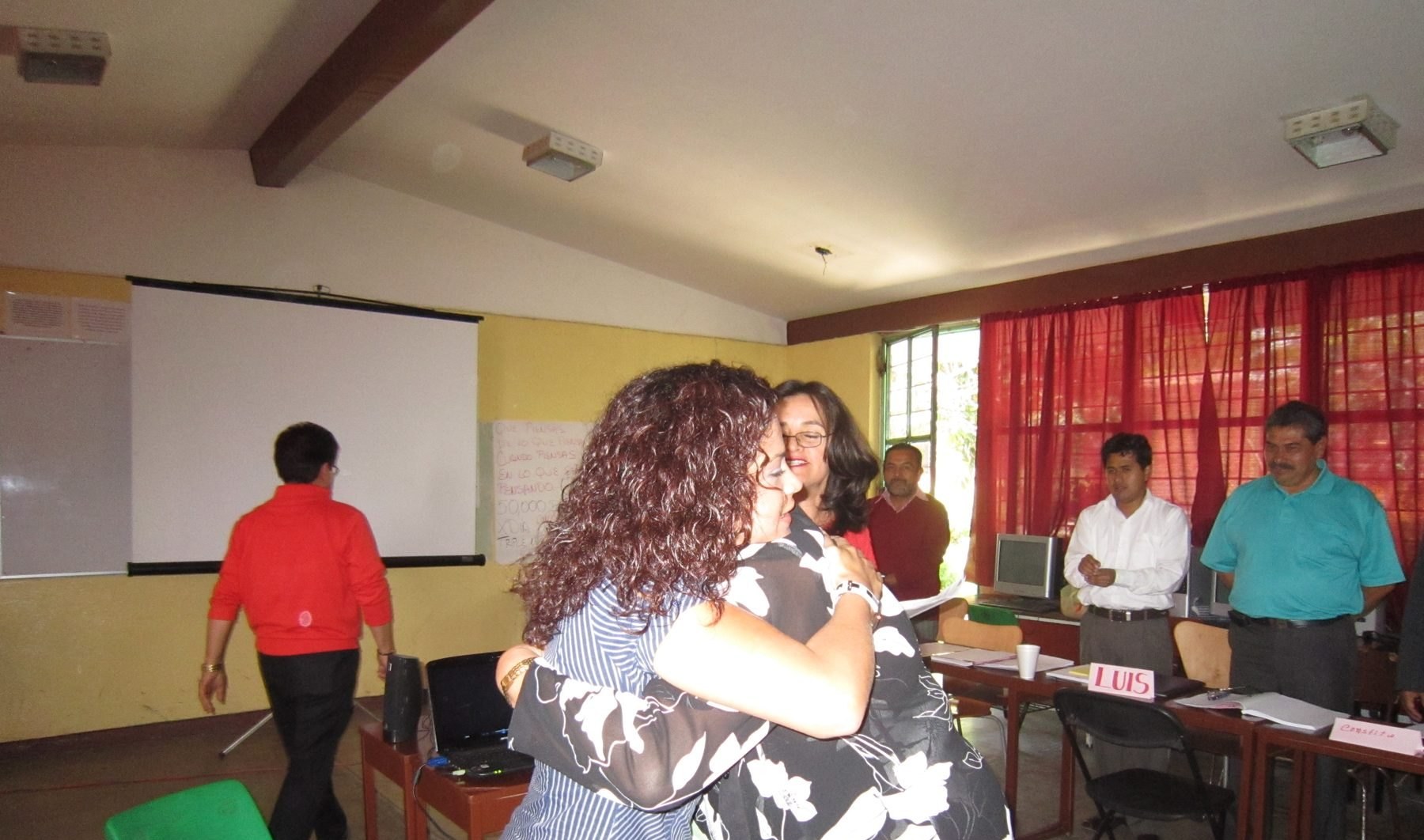 Abrazo entre participantes durante un proceso de desarrollo humano